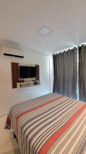 a bedroom with a bed and a flat screen tv at BRISA DE CARAPIBUS in Conde