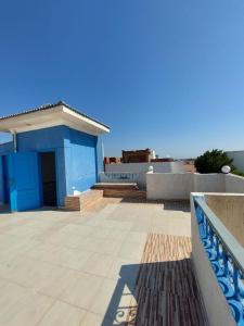 Oocka stay villas في دهب: مبنى أزرق مع أرضية بلاط وفناء
