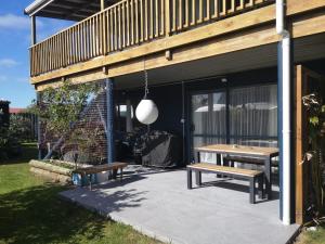 a picnic table and benches on a patio at Houhora Harbour Haven in Pukenui