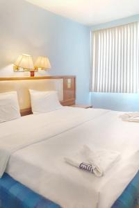 una camera d'albergo con due letti e un asciugamano sul letto di ปิดชั่วคราว ชิดลม a Makkasan