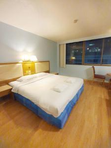 a large bed in a bedroom with a large window at ปิดชั่วคราว ชิดลม in Makkasan