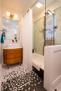 a bathroom with a tub and a sink and a shower at 3 minutes to downtown w/Patio, Art, Fire Pit, BBQ in Lancaster
