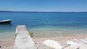 a boat sitting on the shore of a body of water at Marin Apartments in Podstrana