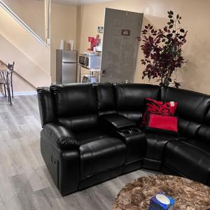 a black leather couch in a living room with a table at The McNeil Mansions in Harrisburg