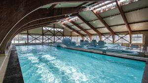 a large indoor swimming pool with a pool slide at Satoyama Auberge & Hot Spring Wellness Spa Sakuragaike Kurgarden in Nanto