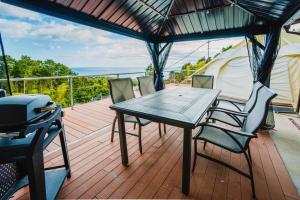 une table et des chaises sur une terrasse avec un grill dans l'établissement 伊豆Cocoグランピングリゾート, à Itō