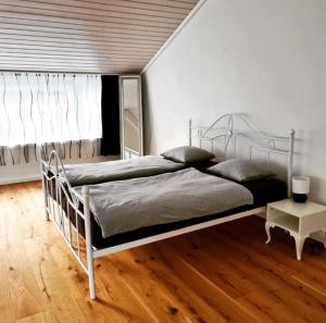um quarto com uma cama de metal e uma janela em Muota River & Industry Apartment by Nature Apartments Switzerland em Muotathal
