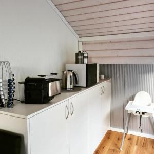 a kitchen with white cabinets with a microwave and appliances at Muota River & Industry Apartment by Nature Apartments Switzerland in Muotathal