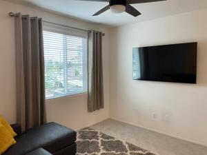 a living room with a couch and a flat screen tv at Sleek & Stylish 3-BR Luxury Townhome - 7 Mile from Las Vegas Strip in Las Vegas