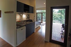 a kitchen with a sink and a door leading to a patio at Kaalba in Maleny