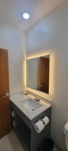 a bathroom with a sink and a mirror at Bungalows Hotel & Hotel Que at Lakeline Austin Cedar Park in Cedar Park
