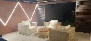 a room with three chairs and a table and lights at Casa Duas Torres in Búzios