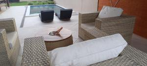 a patio with wicker chairs and a table at Casa Duas Torres in Búzios