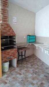 eine Küche mit einem Steinofen und einem Tisch in der Unterkunft pousada&Hostel perola mar in Mongaguá