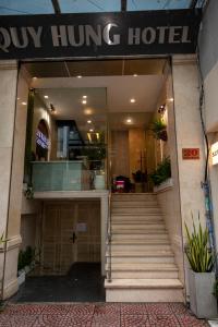 a hotel entrance with stairs in front of a building at Quy Hung Hotel Central in Ho Chi Minh City