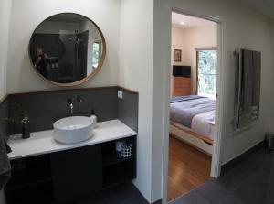 a bathroom with a sink and a mirror and a bed at Kaalba in Maleny