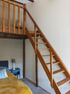uma cama alta com escadas de madeira num quarto em Rêve d’Emma em Plan-dʼOrgon