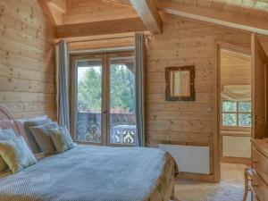 Dormitorio en cabaña de madera con cama y ventana en Chalet Megève, 6 pièces, 10 personnes - FR-1-453-309, en Megève