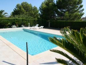 uma piscina com duas espreguiçadeiras ao lado em Villa L'Ametlla de Mar, 5 pièces, 8 personnes - HISP-217-213 em L'Ametlla de Mar