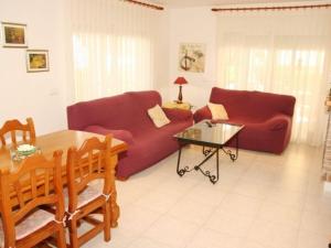 uma sala de estar com dois sofás vermelhos e uma mesa em Villa L'Ametlla de Mar, 5 pièces, 8 personnes - HISP-217-213 em L'Ametlla de Mar