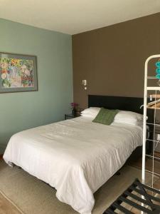 a bedroom with a large bed with white sheets at Aquavilla Studio in Plimmerton
