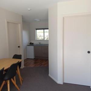 a dining room with a table and a kitchen at Flaxbourne Motels in Ward