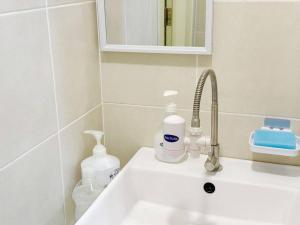 a bathroom sink with soap and bottles on it at S3 2Room Sunway Geo 1-8PAX Sunway Medical Centre in Kampong Penaga +21 photos