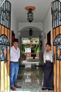 2 personnes debout à l'entrée d'une maison dans l'établissement Chaska Hotel, à Otavalo