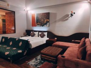 a bedroom with a bed and a chair and a couch at Foresto Sukhothai Guesthome in Sukhothai