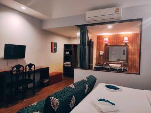 una camera d'albergo con un letto e un grande specchio di Foresto Sukhothai Guesthome a Sukhothai