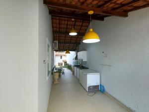 a kitchen with two lights and a long hallway at Luxo nas Ondas: Casa de Praia de Alto Padrão in São João da Barra