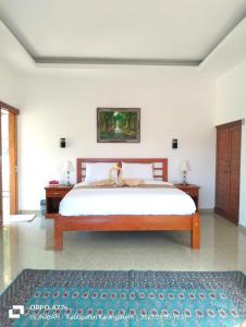 a bedroom with a large bed and two night stands at Pondok Wisata Balty Bali in Amed