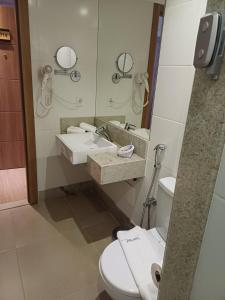 a bathroom with a sink and a toilet and a mirror at Hotel Apart Pedra Azul - Aracê - Domingos Martins in Domingos Martins