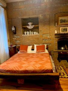 a bedroom with a large bed with a brick wall at Dzveli Galavani -Old Wall in Tʼelavi