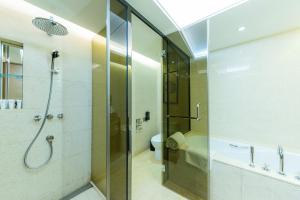 Shenzhen LANGYUE International Hotel في Longgang: حمام مع دش زجاجي ومرحاض