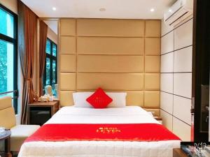 une chambre avec un grand lit recouvert d'une couverture rouge dans l'établissement Lê Yên Hotel HN - by Bay Luxury, à Hanoï