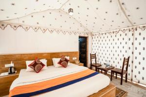 a bedroom with a bed and a table and chairs at Desert Safari Camp & Resort Sam in Sām