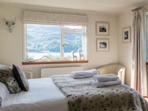 a bedroom with two beds and a large window at Tigh-na-creige in Feorlean