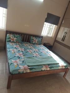 1 dormitorio con 1 cama con colcha de flores en Swayamkrushi 3rd Floor, en Hyderabad