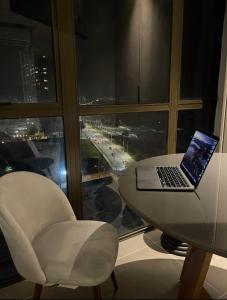 een laptop op een tafel met een stoel en een raam bij Loft Residence Beira Mar 1103 in Maceió