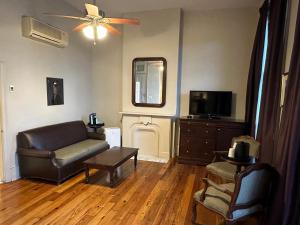 uma sala de estar com um sofá e uma televisão em Inn on St. Ann, a French Quarter Guest Houses Property em Nova Orleans