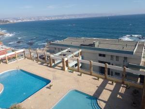 an aerial view of a building with a swimming pool and the ocean at Reñaca. Increíble vista al mar, pasos del sector 5 in Viña del Mar