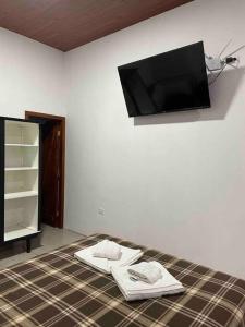 巴克里索莫雷諾港的住宿－Family Apart Studio，卧室配有一张壁挂式平面电视的床。