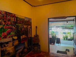 um quarto com uma guitarra e uma pintura na parede em DD Guest House em Pakse
