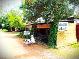 a scooter parked in front of a small building at DD Guest House in Pakse