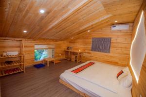 een slaapkamer met een bed in een houten hut bij Meo Vac Valley in Mèo Vạc