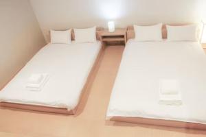 two beds in a small room with white sheets at Fortune house 步行直達大阪京瓷巨蛋 直達梅田 桜川4丁目 in Osaka