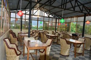 a restaurant with tables and chairs and windows at Pushkar Retreat Resort - The Nature and Mountain View Resort ,Pushkar in Pushkar