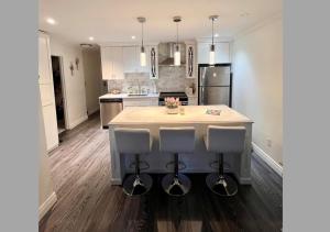 a kitchen with a island with two bar stools at Ocean Villa -1BDR- King bed- Kitsilano beach w/parking in Vancouver