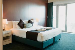 um quarto com uma cama grande e uma janela grande em Ceduna Foreshore Hotel Motel em Ceduna